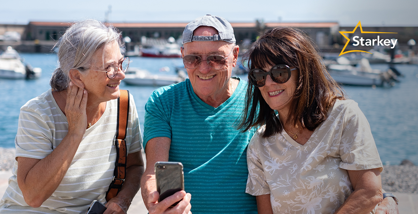Image of two senior women and one senior man taking a selfie in front of a bay